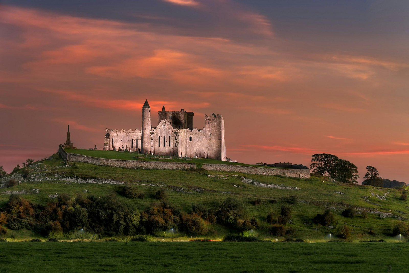 The Rock of Cashel on its limestone outcrop under a pink sunset sky